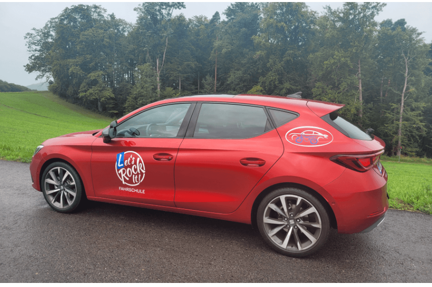 Rotes Fahrschulauto Seat Leon Hola FR von Let's Rock It mit Logo an der Tür